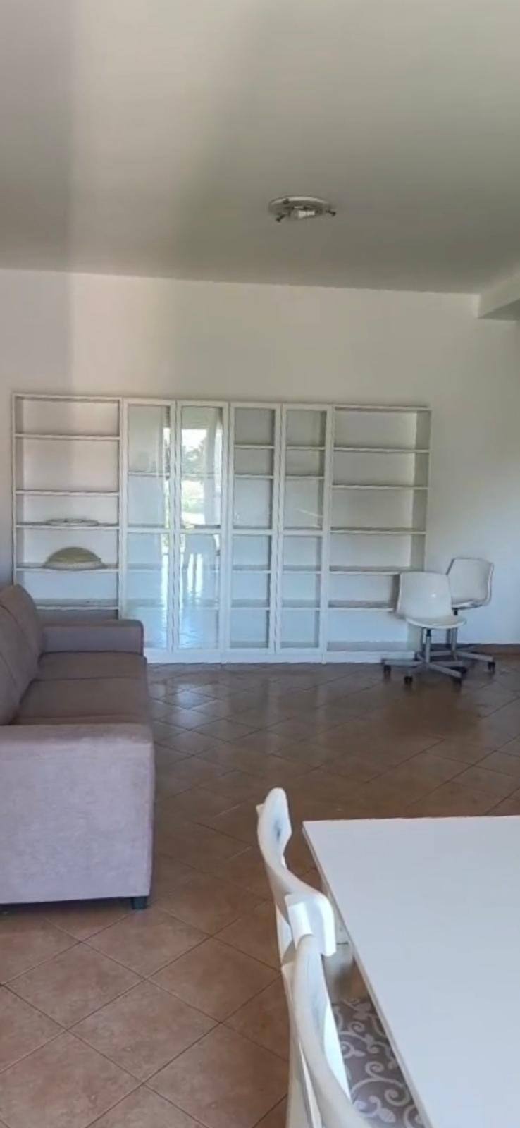 Soggiorno dell'appartamento in affitto a Fucecchio, con libreria a muro e tavolo da pranzo.