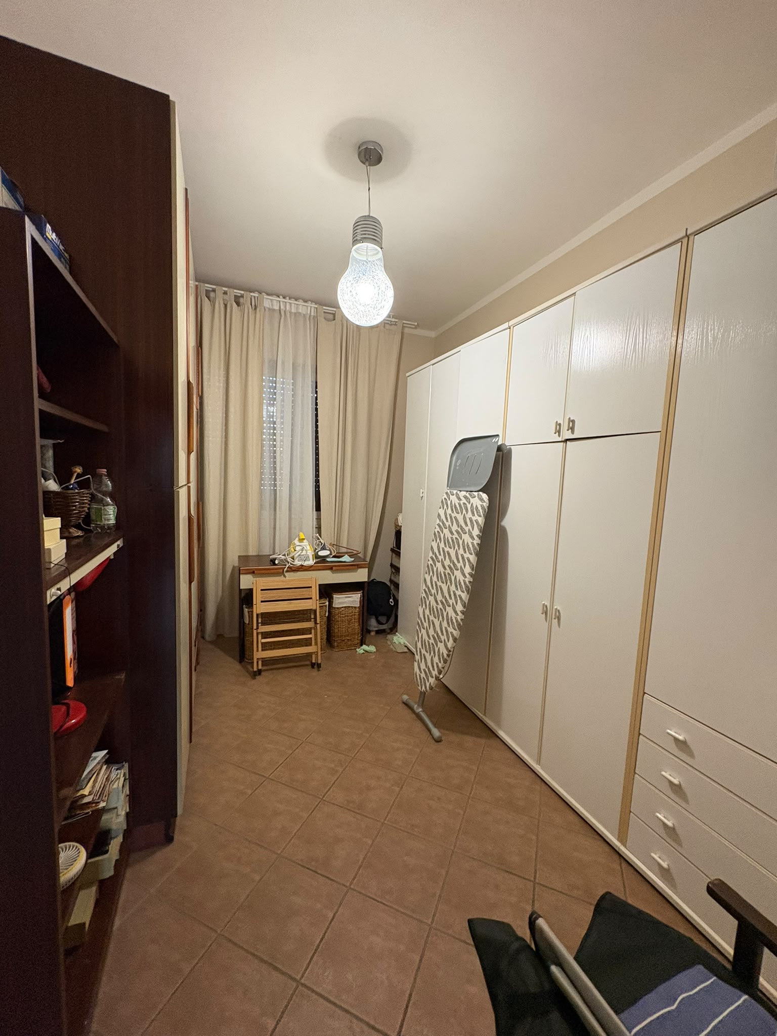 Camera usata come studio, con armadio a muro a tutta parete, scrivania e finestra.