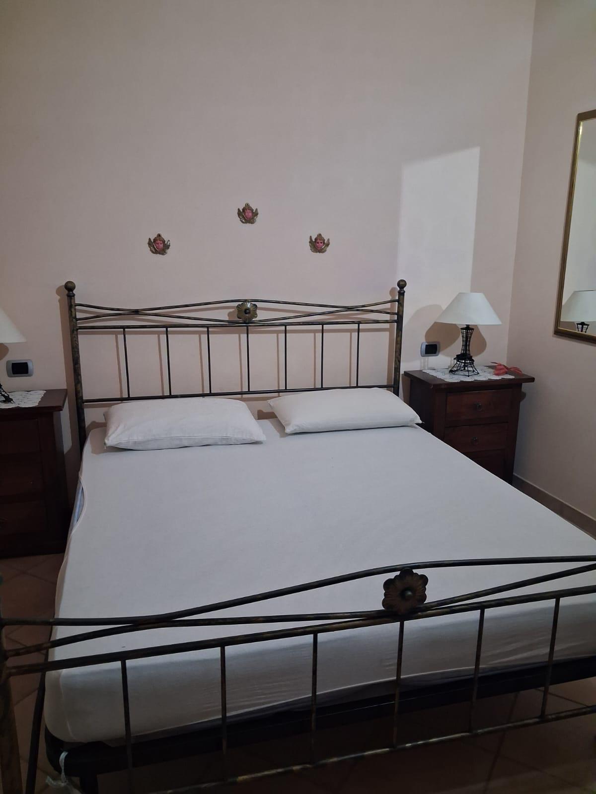 Camera matrimoniale con letto in ferro battuto bianco dell'appartamento in affitto a Montopoli in Val d'Arno.