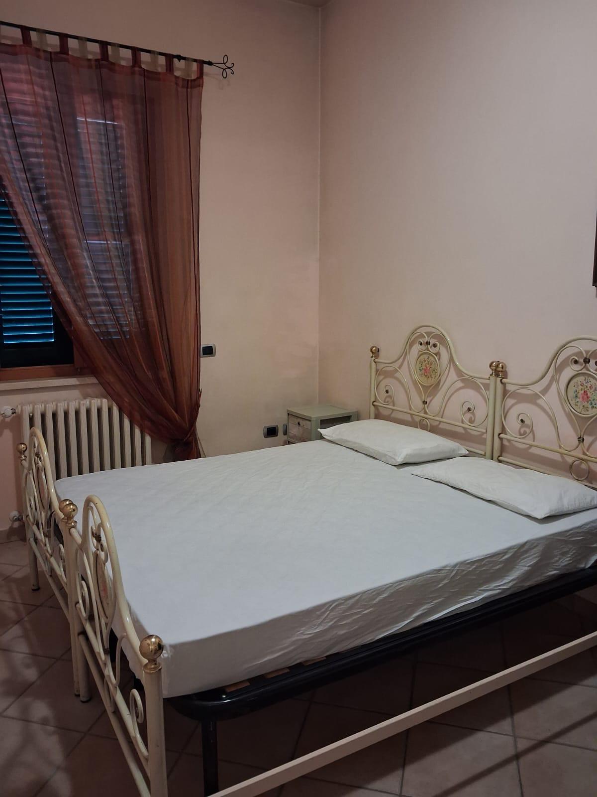Cameretta con letto in ferro battuto nero dell'appartamento in villa a Montopoli in Val d'Arno.