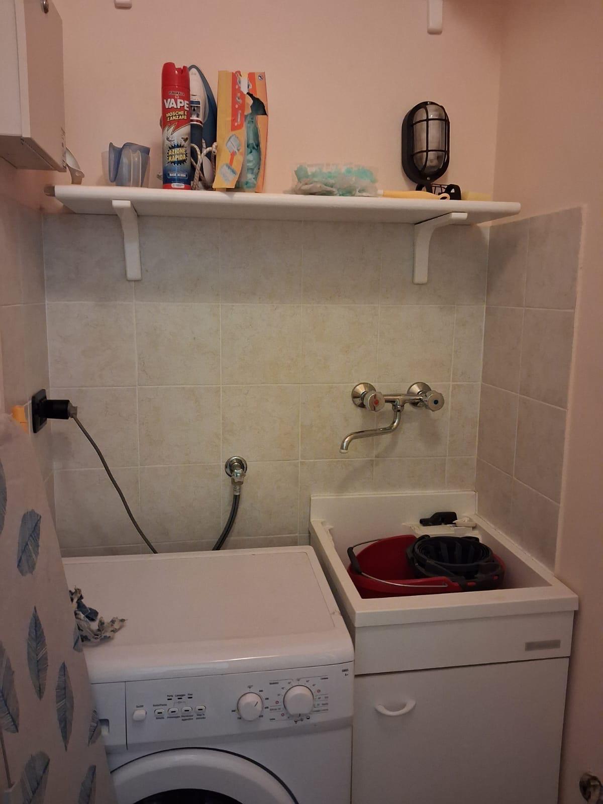 Lavanderia con lavatrice e lavandino dell'appartamento in affitto a Montopoli in Val d'Arno.