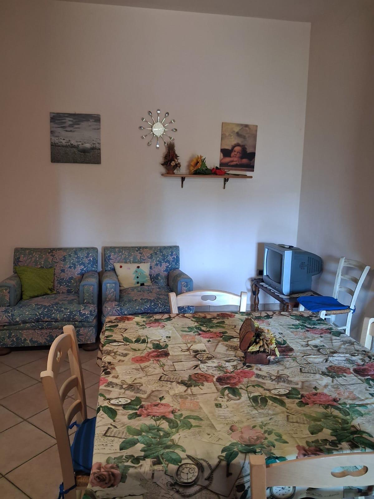 Soggiorno con poltrone, tavolo e credenza dell'appartamento in villa a Montopoli in Val d'Arno.